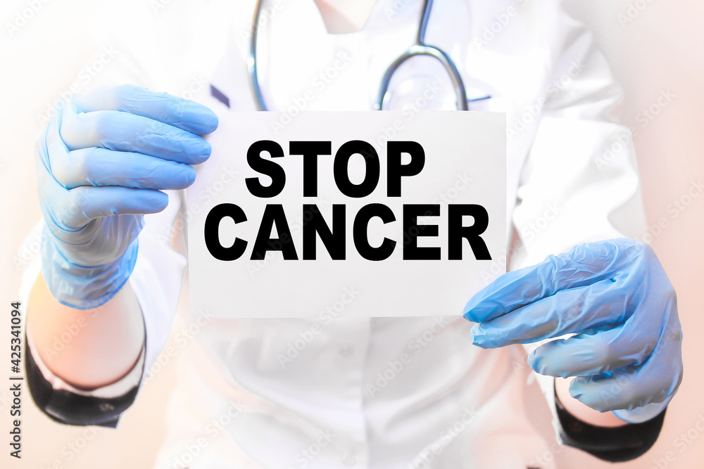 The doctor's blue - gloved hands show the word STOP CANCER - . a gloved hand on a white background. Medical concept. the medicine The doctor's blue - gloved hands show the word STOP CANCER - . a gloved hand on a white background. Medical concept. the medicine