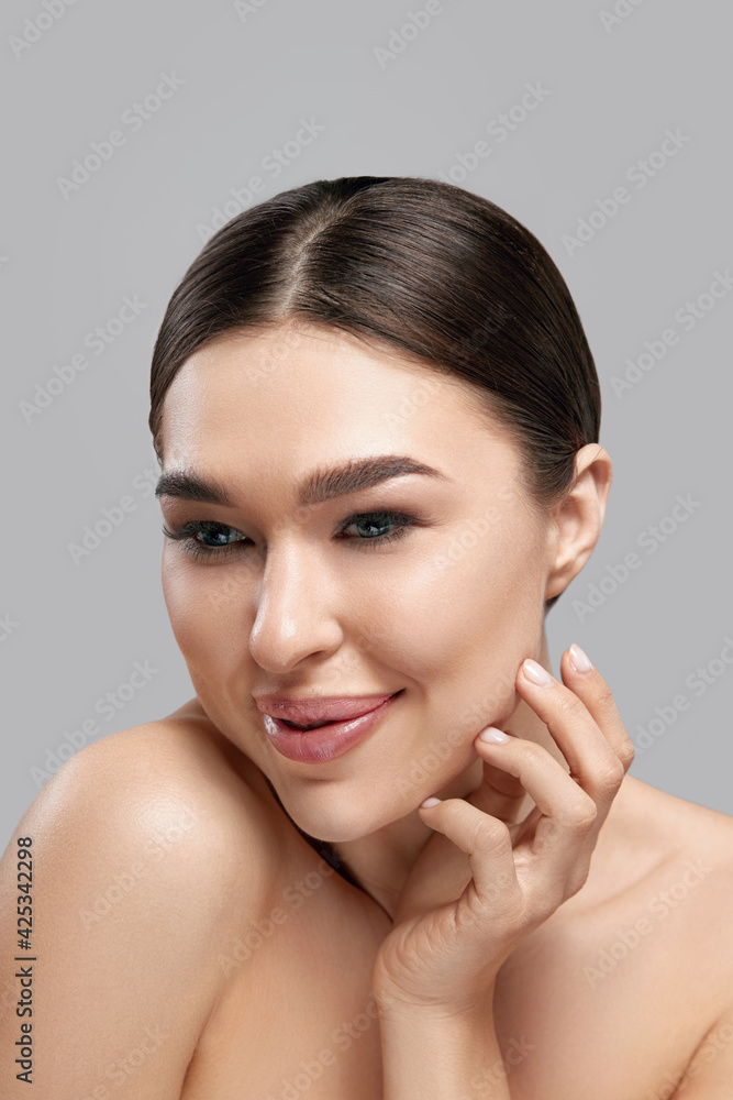 Beauty Face. Beautiful Woman With Natural Makeup Applying Cream To Her Face . Closeup Portrait Of Model Girl With Healthy Smooth Facial Skin. Beauty Face. Beautiful Woman With Natural Makeup Applying Cream To Her Face . Closeup Portrait Of Model Girl With Healthy Smooth Facial Skin.