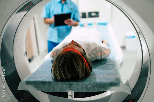 Young woman patient is ready to do magnetic resonance imaging in the modern hospital laboratory photo