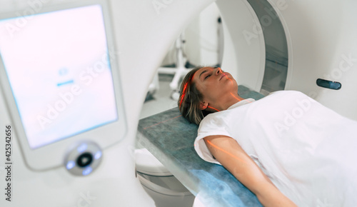 Young woman patient is ready to do magnetic resonance imaging in the modern hospital laboratory photo