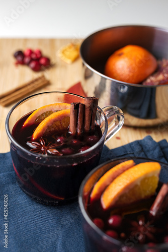 Hot red mulled wine with orange and spices in a saucepan. Christmas celebration.