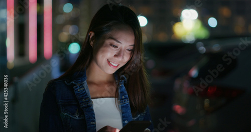 Woman use of smart phone in city at night