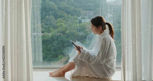 Woman read book on tablet and sit beside window