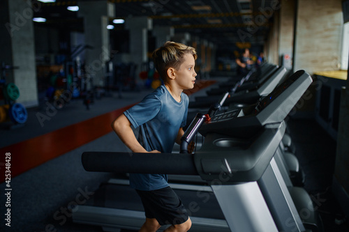 Boy doing exercise on treadmill, running machine