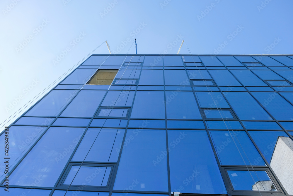 Construction of tall corporate buildings from blue glass. Industrial skyscrapers in the business office center. Copy space. Bottom view. Construction of tall corporate buildings from blue glass. Industrial skyscrapers in the business office center. Copy space. Bottom view.