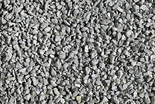 Monochrome light gray decorative pebbles used in the garden or yard. Background and texture