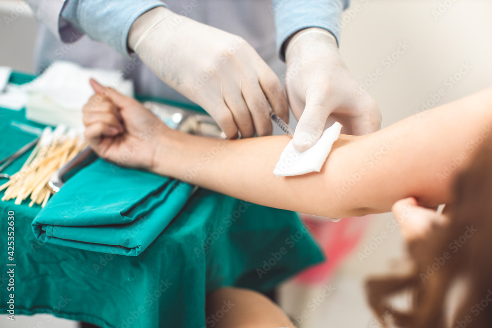 Fototapeta premium Close up of a young woman getting vaccinated.Medicine and health care concept. Asian doctor is taking care patient woman in hospital.