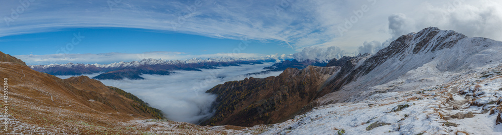 Amazing morning panorama of the Italian-Austrian border crest and the Drava - Drau valley covered with clouds and in the background the main Austrian peaks. Panoramas that inspire tranquility