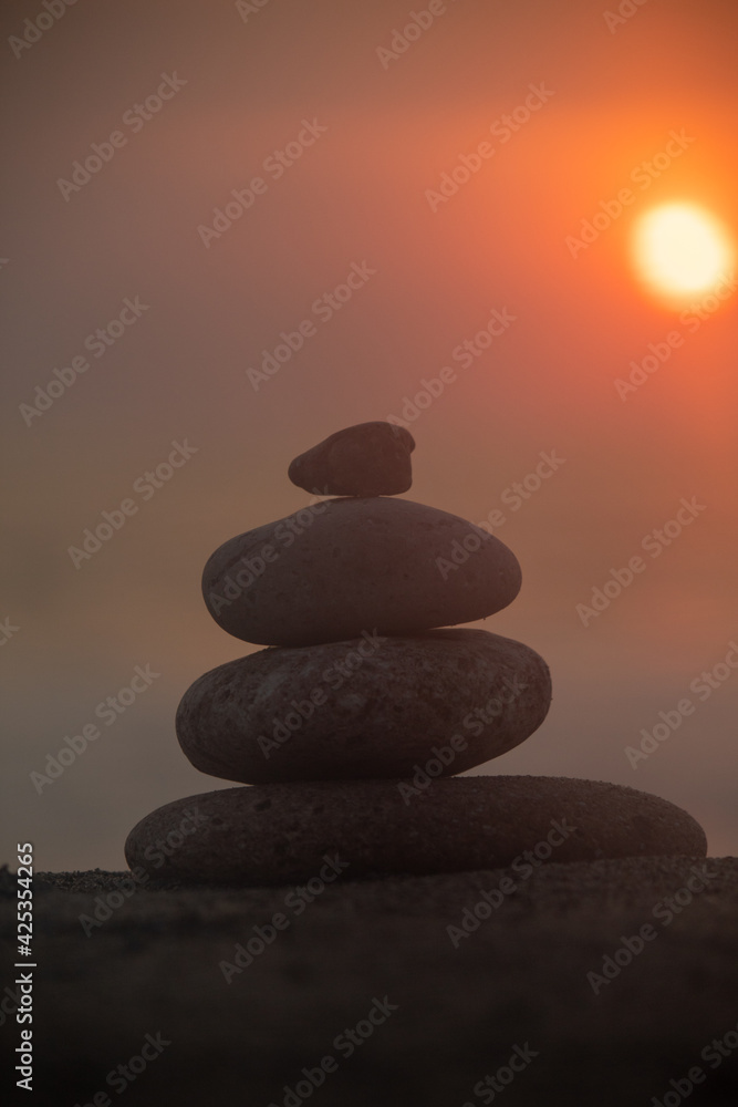 A pillar of rocks with a sunset taking place in the background