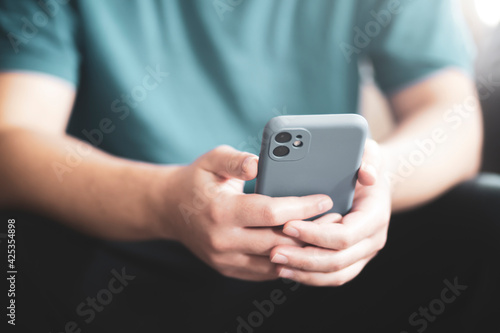 Teenager holding mobile phone in hand