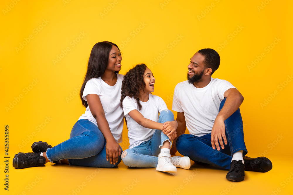 African American man talking with his smiling wife and daughter African American man talking with his smiling wife and daughter