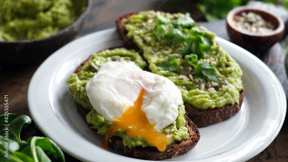 Toast with mashed avocado and poached egg. Rye bread avocado toast with