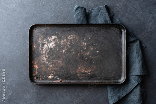 Old rusty black baking sheet background, top view, copy space