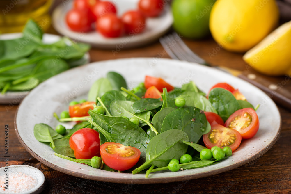 Healthy green salad with mini spinach, tomatoes and green peas. Low calorie diet weight loss food Healthy green salad with mini spinach, tomatoes and green peas. Low calorie diet weight loss food