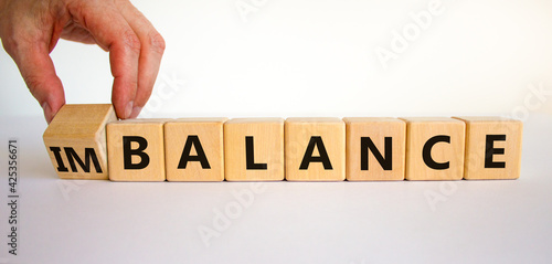 Balance or imbalance symbol. Businessman turns cubes and changes the word imbalance to balance. Beautiful white background, copy space. Business, balance or imbalance concept.