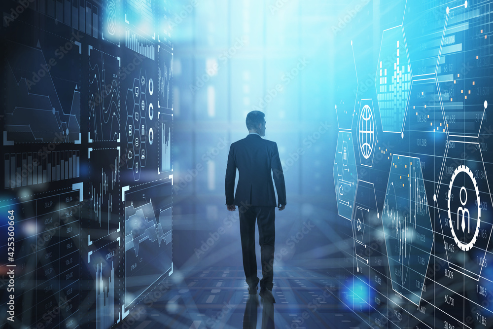 Businessman wearing formal suit is walking between two digital i Businessman wearing formal suit is walking between two digital i