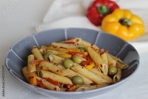 Butter pasta with vegetables. Boiled pasta sauteed in butter with garlic and oregano and tossed with olives and stir fried bell peppers.