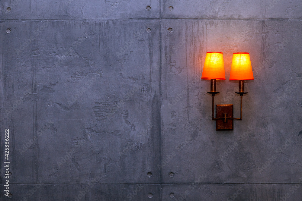 lamp (sconce) on a rough, gray concrete wall