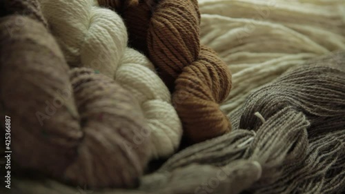 Zoomed in video showing fruitful results of wool making process, dyed yarn of different shades are stacked neatly in together in groups. 