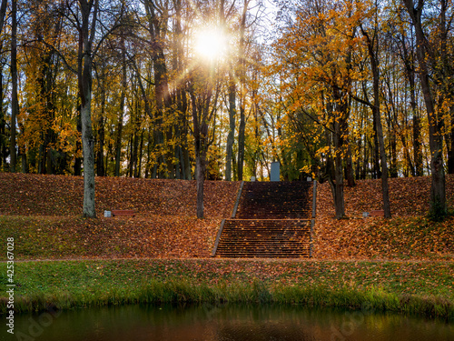 Ancient sunny autumn evening park with a large stone staircase.