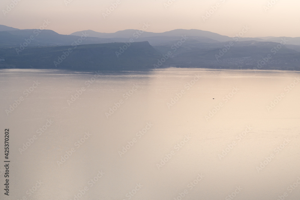 Misty morning on the Sea of Galilee, with Mount Arbel seen through fog in the distance