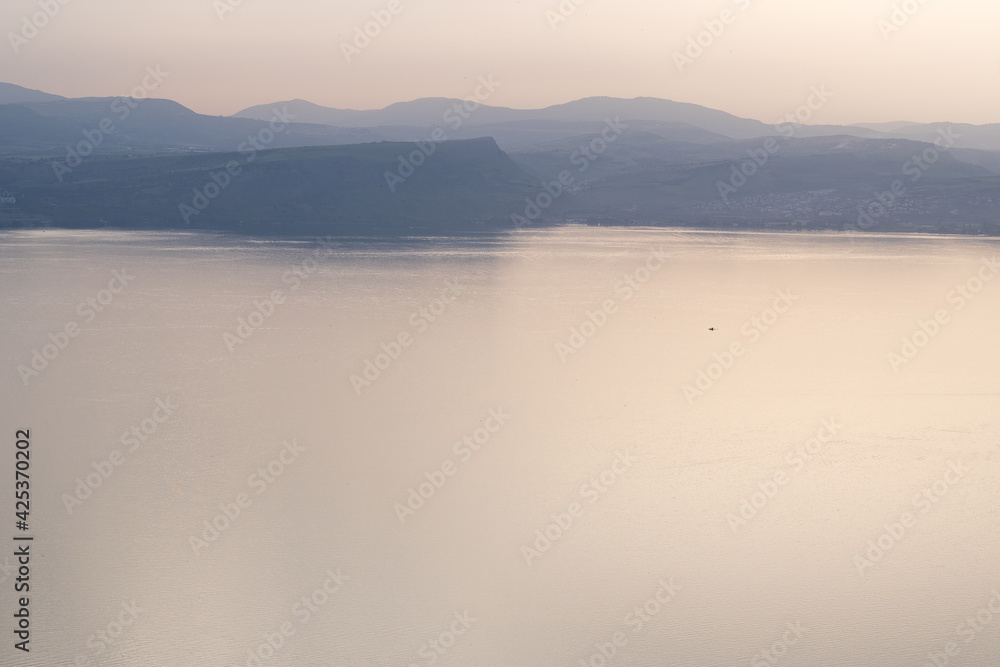Fototapeta premium Misty morning on the Sea of Galilee, with Mount Arbel seen through fog in the distance