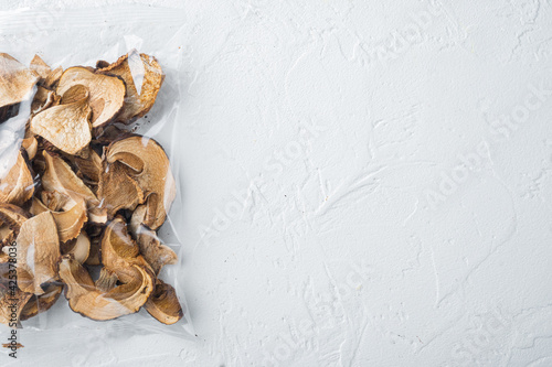 Dried porcini mushrooms, on white background, in plastic pack, top view flat lay , with space for text  copyspace