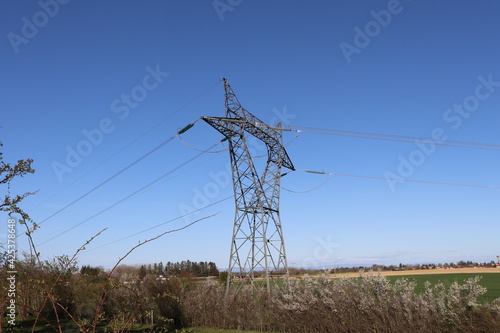 Pylônes électriques haute tension sur fond de ciel bleu, département du Rhône, France photo