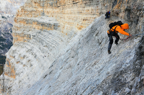 Alpinist climbing ferrata on Tofana di Rozes, Dolomites, Italy, Europe photo