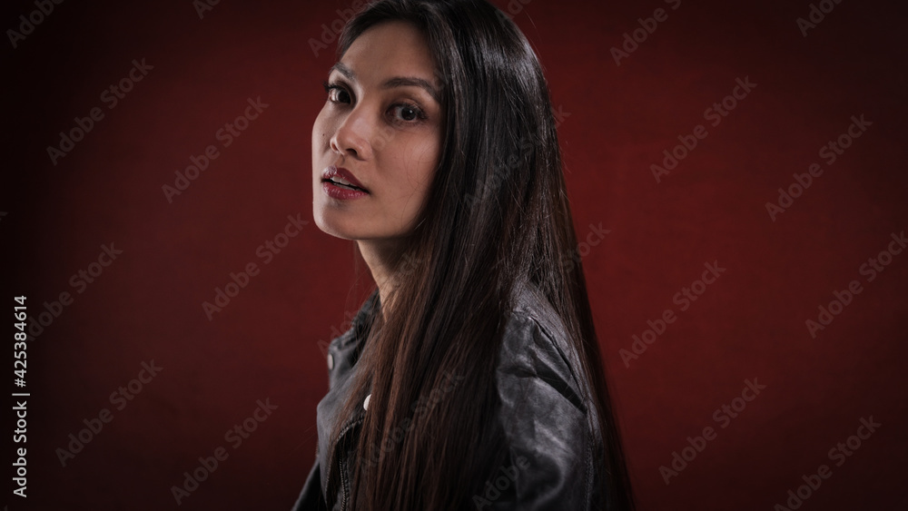 Fototapeta premium Young pretty woman in black leather jacket posing for the camera - studio photography