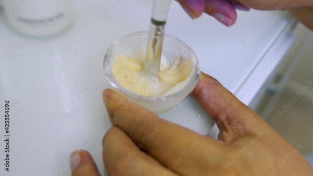 Woman beautician stirring cream with a special spatula Woman beautician stirring cream with a special spatula