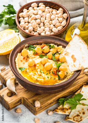 Hummus with olive oil and paprika at light kitchen table.