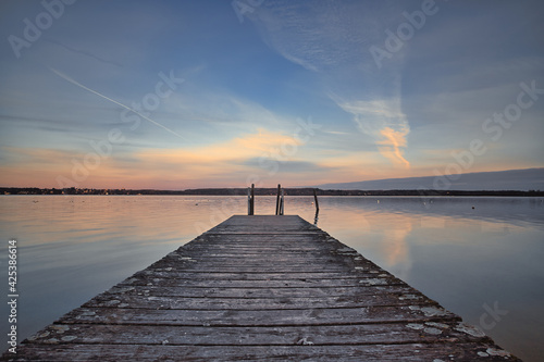 Early sunrise with clouds and pier on the lake