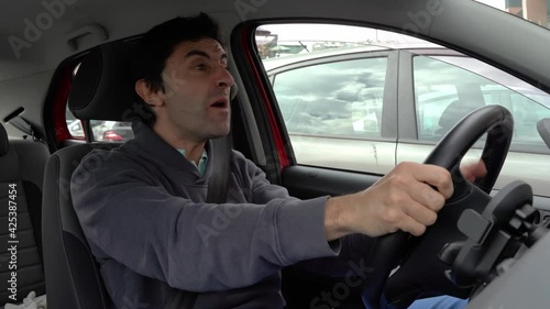 Furious man gesticulates with hands and horns driving on traffic jam. Crazy driver yelling from car desperately. Stress, traffic rush hour, anxious, madness, rudeness concepts