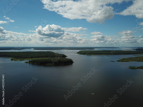 Beautiful river landscape top view from drone. Green small islands against a background of blue sky and white clouds © berendoska