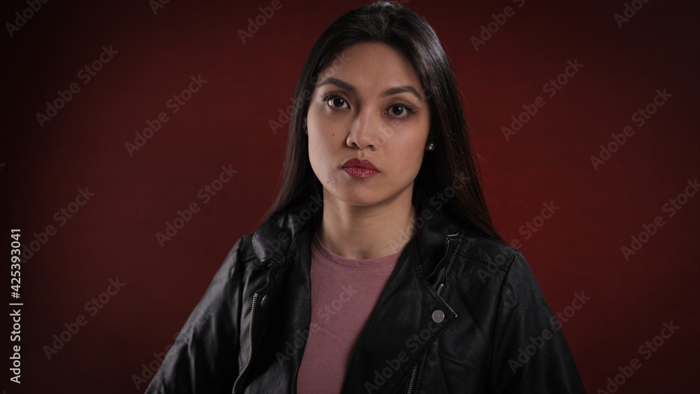 Young self-confident woman against a red background - studio photography Young self-confident woman against a red background - studio photography