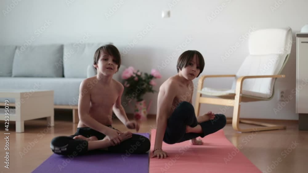 Children, making exercises at home in sunny room, making lotus flower exercise and staying fit Children, making exercises at home in sunny room, making lotus flower exercise and staying fit