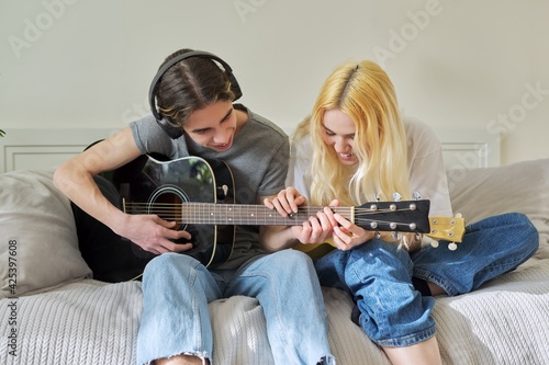 Creative teenagers friends with musical instruments, acoustic guitar and ukulele