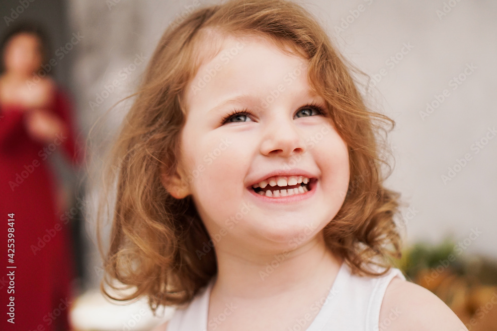Portrait of a happy three-year-old girl. The blonde-haired child laughs Portrait of a happy three-year-old girl. The blonde-haired child laughs