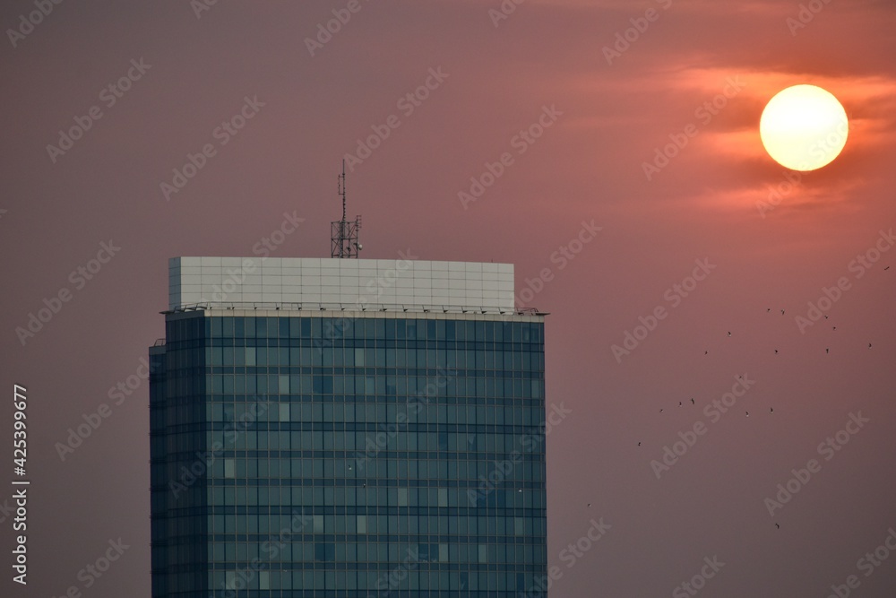 Obraz premium Top floors of a skyscraper and sunset in the background