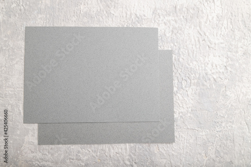 Gray paper business card, mockup on gray concrete background. Blank, flat lay, top view