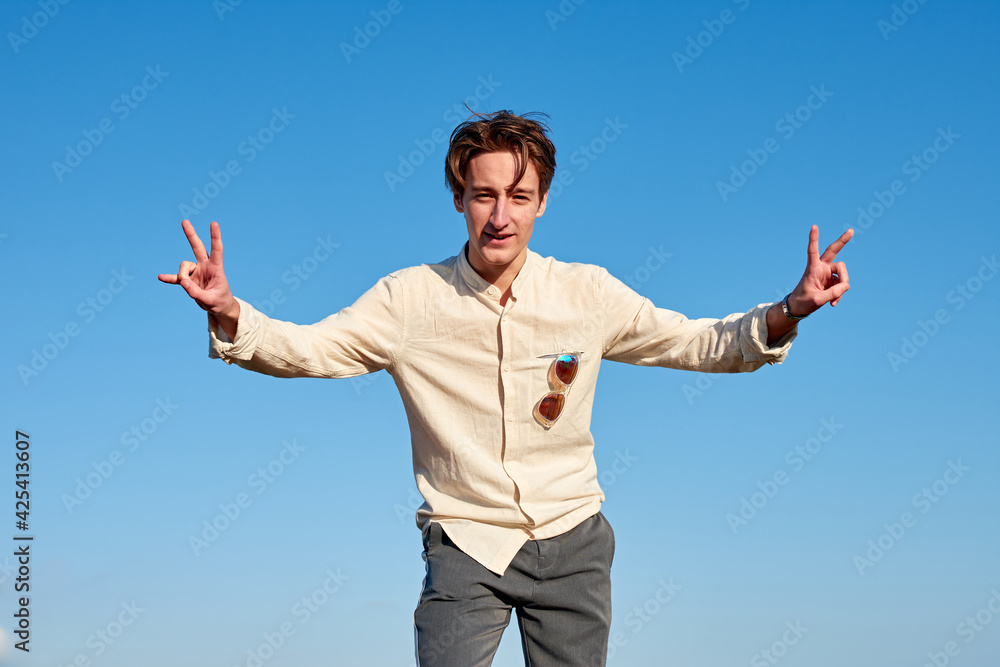 A Caucasian man from Spain making victory signs with both hands on clear sky background A Caucasian man from Spain making victory signs with both hands on clear sky background