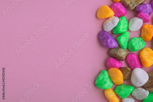 Colored stones, on a pink background, top view, lying on a flat surface © Tasha