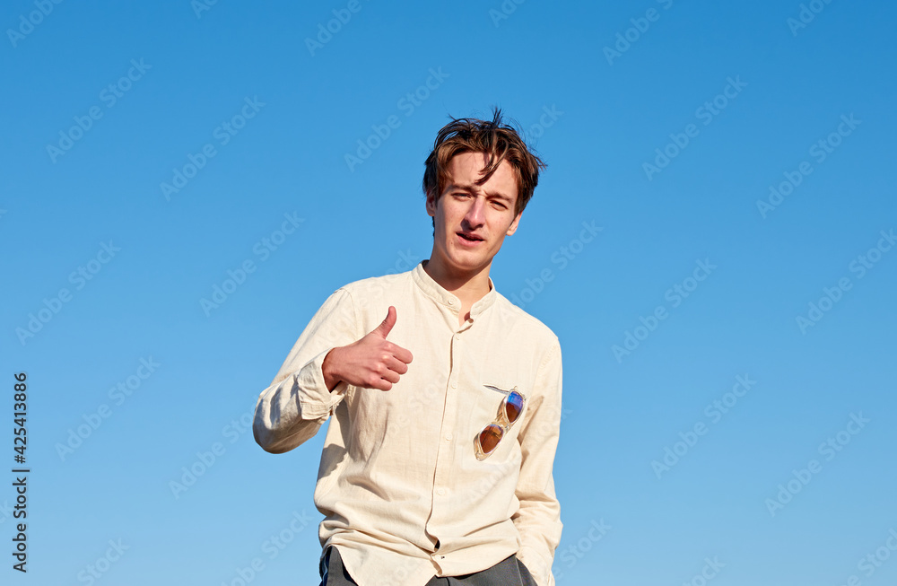 A Caucasian man from Spain making a thumbs up sign on clear sky background