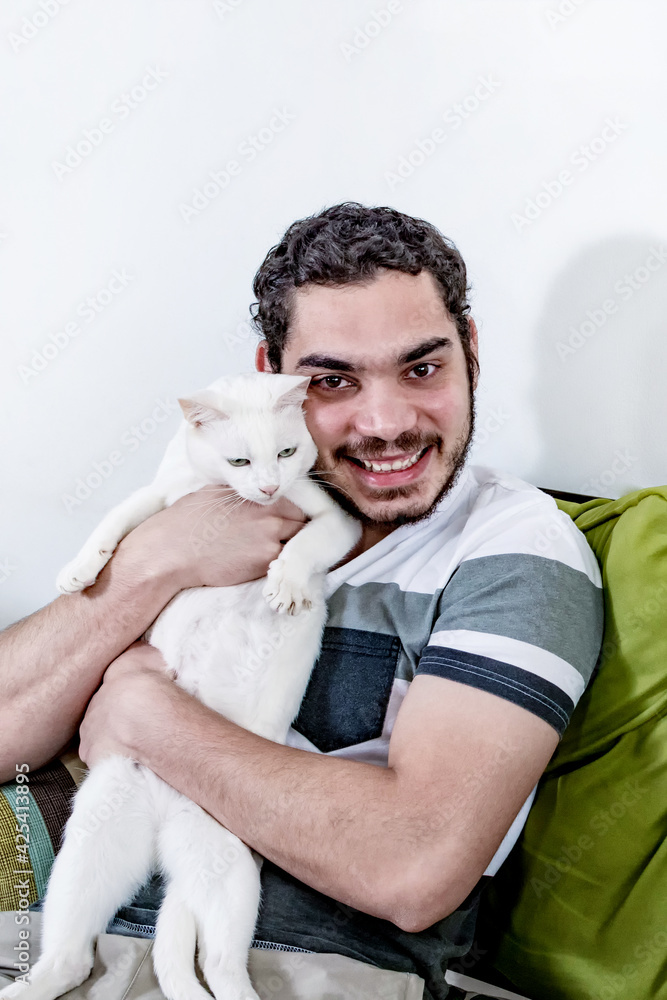 Happy young man with his cat looking at the camera. Happy young man with his cat looking at the camera.