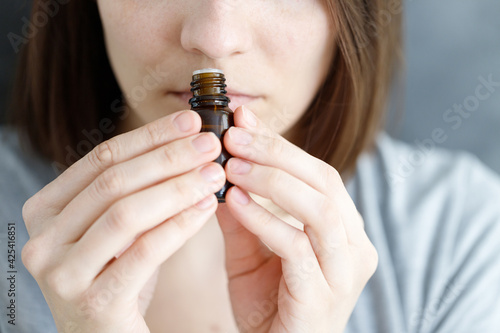 Photos young and beautiful Caucasian women sniff a tube of aromatic oil, to check for c