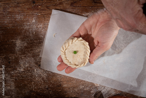 Older woman and young woman making traditional Mallorcan empanadas. Mallorcan empanadas. Easter traditions. Hands doing culinary activities.