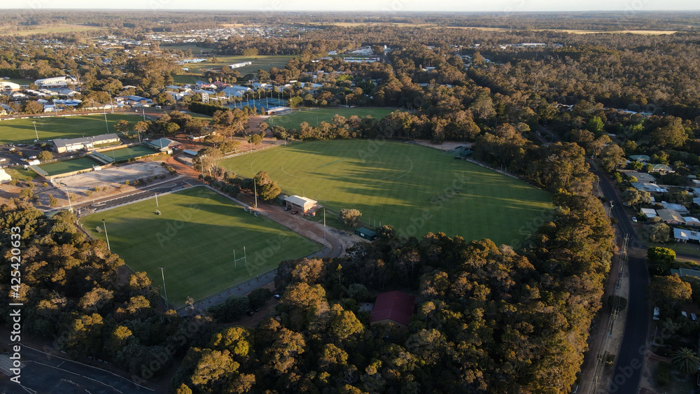 Aerial shot of Margaret River Town and empty Football field at sunset in Australia.