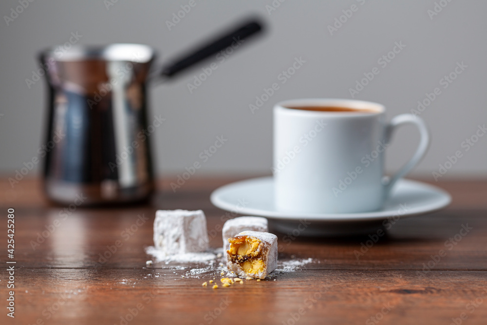 Traditional Turkish coffee served in classical cups with Turkish delights. A metal coffee pot is in the background. Traditional Turkish coffee served in classical cups with Turkish delights. A metal coffee pot is in the background.