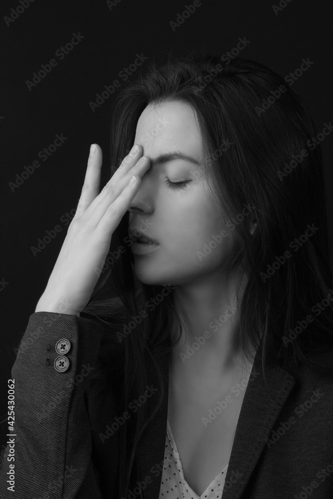 Black and white portrait of a young brunette woman in a studio on a black background Black and white portrait of a young brunette woman in a studio on a black background